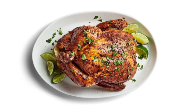 Whole roasted chicken with lime and cilantro on plate