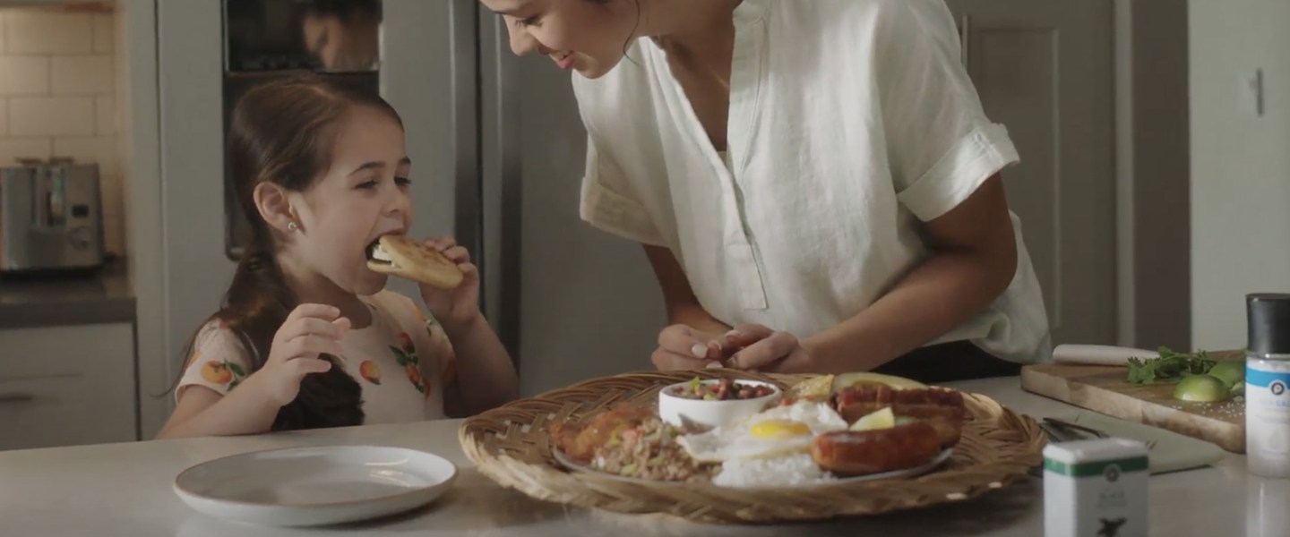 woman and girl eating in kitchen