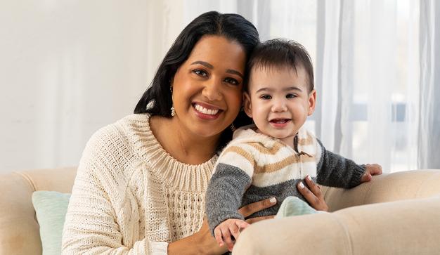 Un asociado sonriente de Publix con un hijo sano de 15 meses.