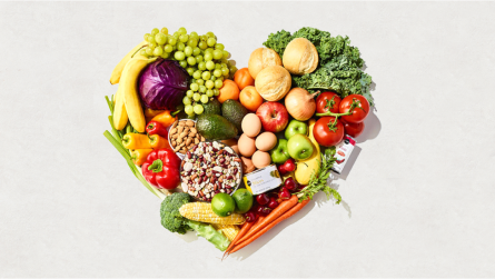 Un arreglo en forma de corazón hecho con frutas y verduras frescas.