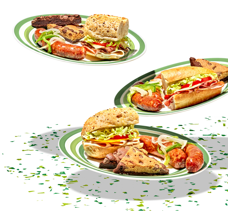 plates of sub sandwiches with sausages, brownies, and brookies