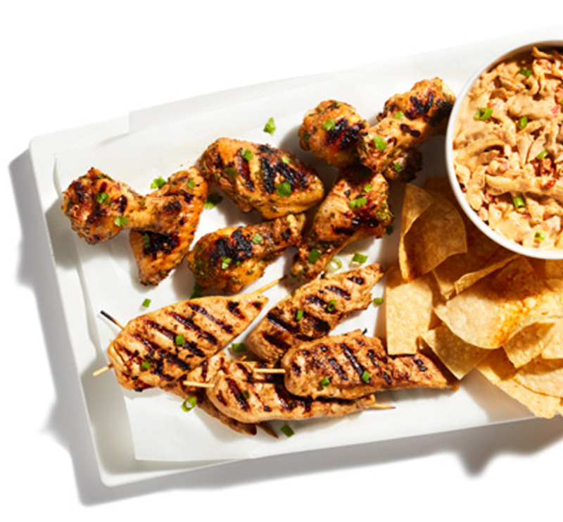 plate of grilled chicken, chips, and pasta salad
